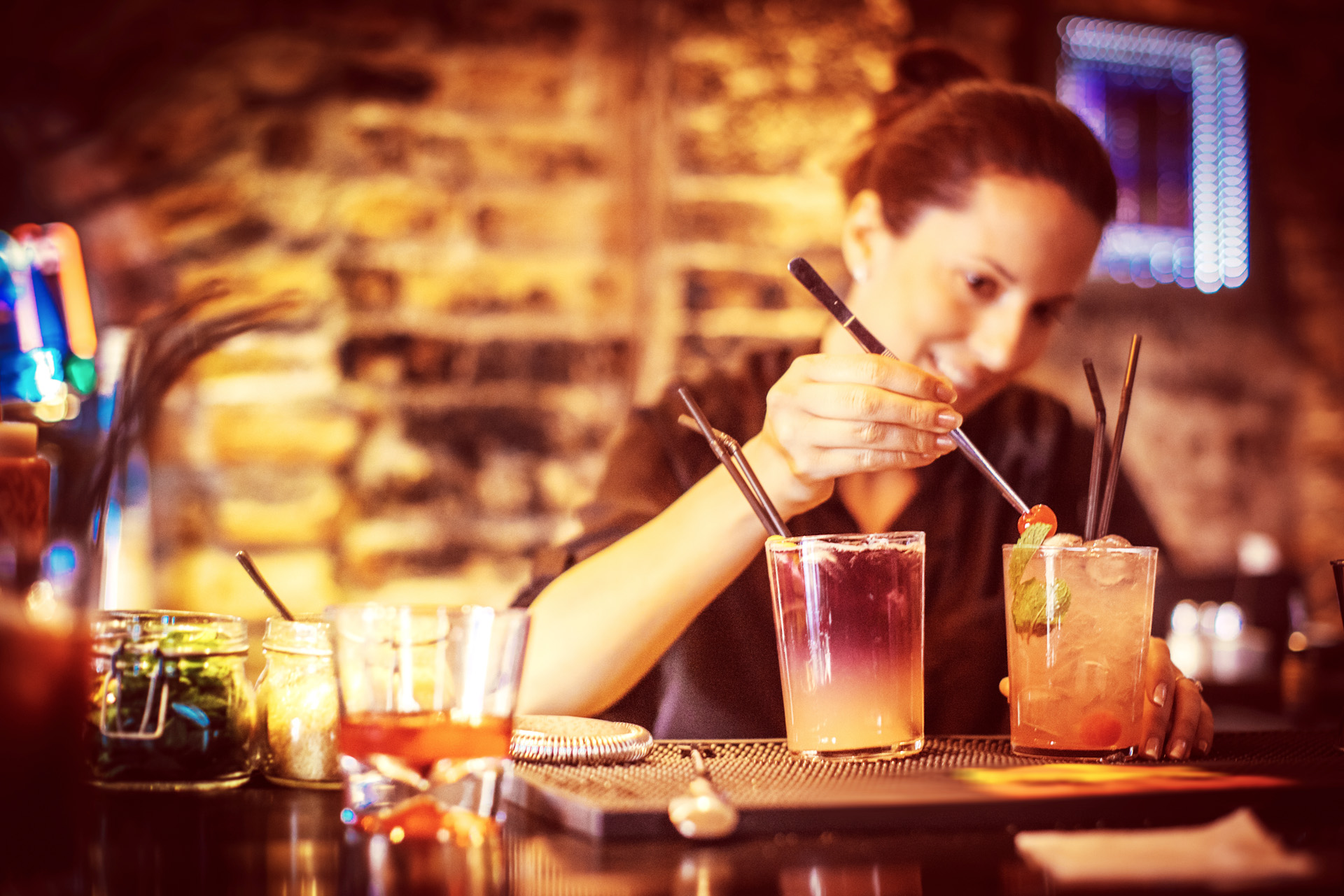 Une barmaid en alternance prépare des cocktails